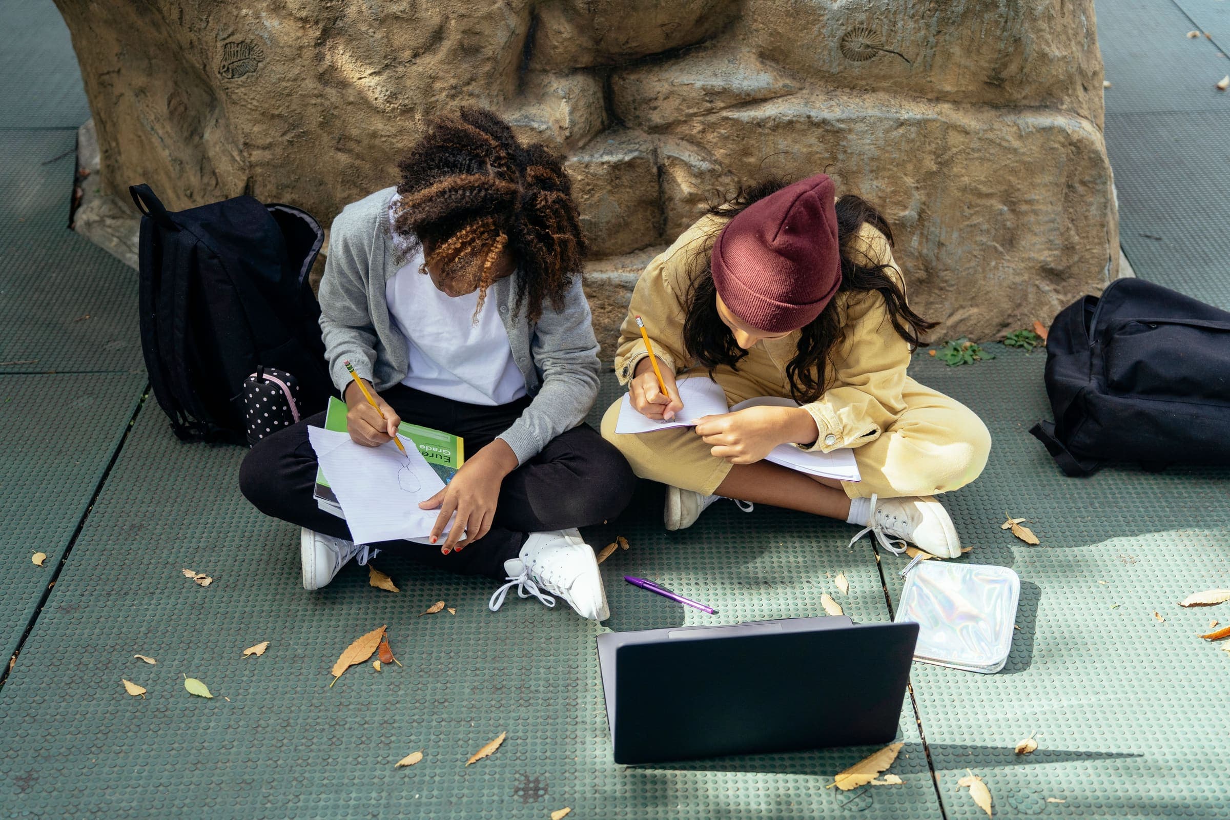 An educator reading with two young students.